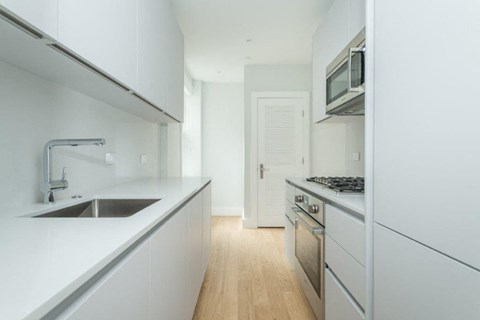 A modern kitchen with white cabinets and stainless steel appliances.
